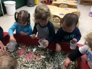 Toddlers engaging in scooping and pouring